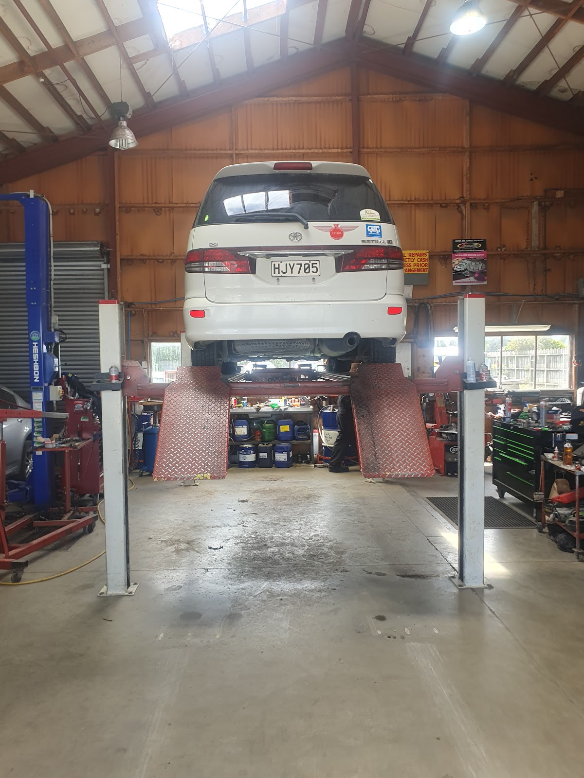 A van up on the four post hoist inside the Teviot Street Autos workshop